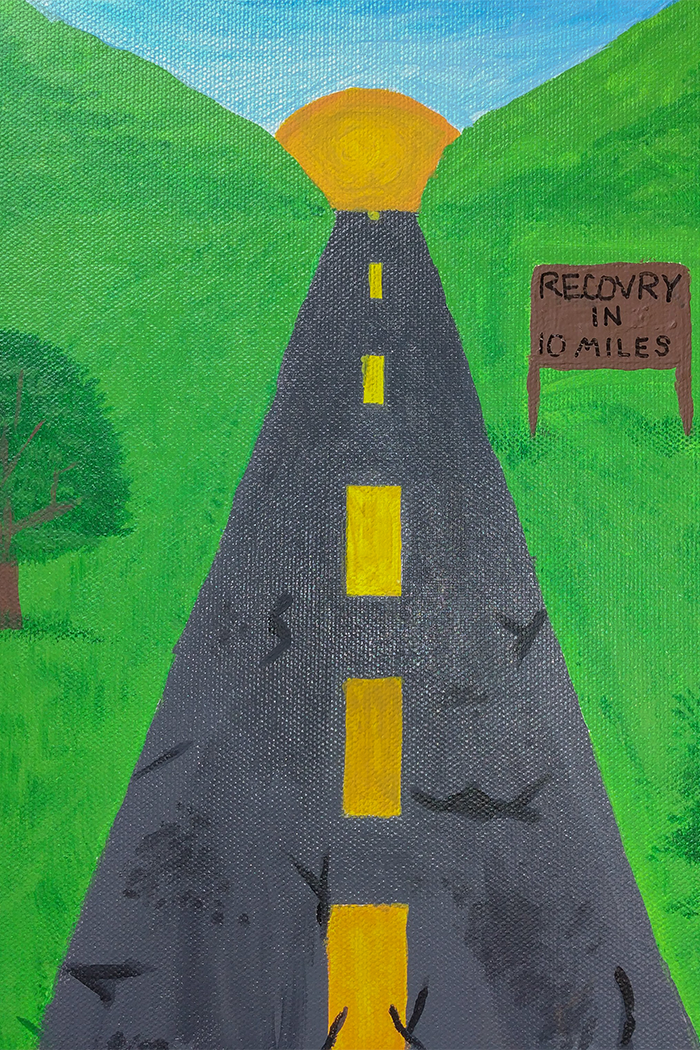 a highway extends into a valley between to green hills where the sun is setting. A sign to the right of the road states 'Recovery in 10 miles'