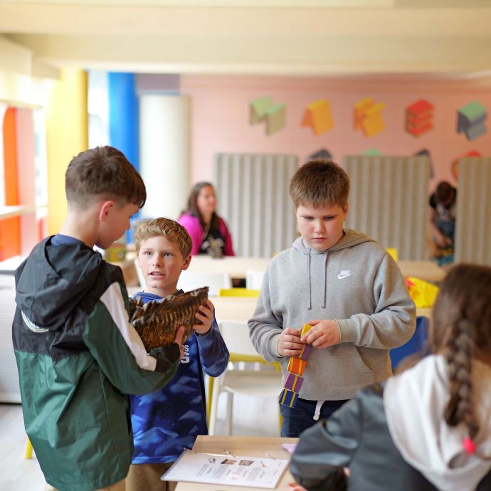 Three young boys looking at something at the History Maker Space 