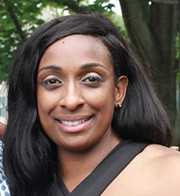 A color photo of a smiling black woman with shoulder length black hair.