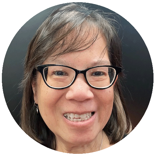 A woman with glasses and black hair smiling at the camera.