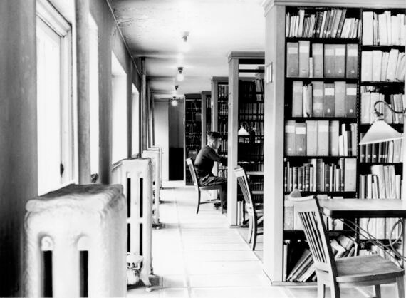 Young man studying at a table in the library stacks of the Wisconsin Historical Society library.