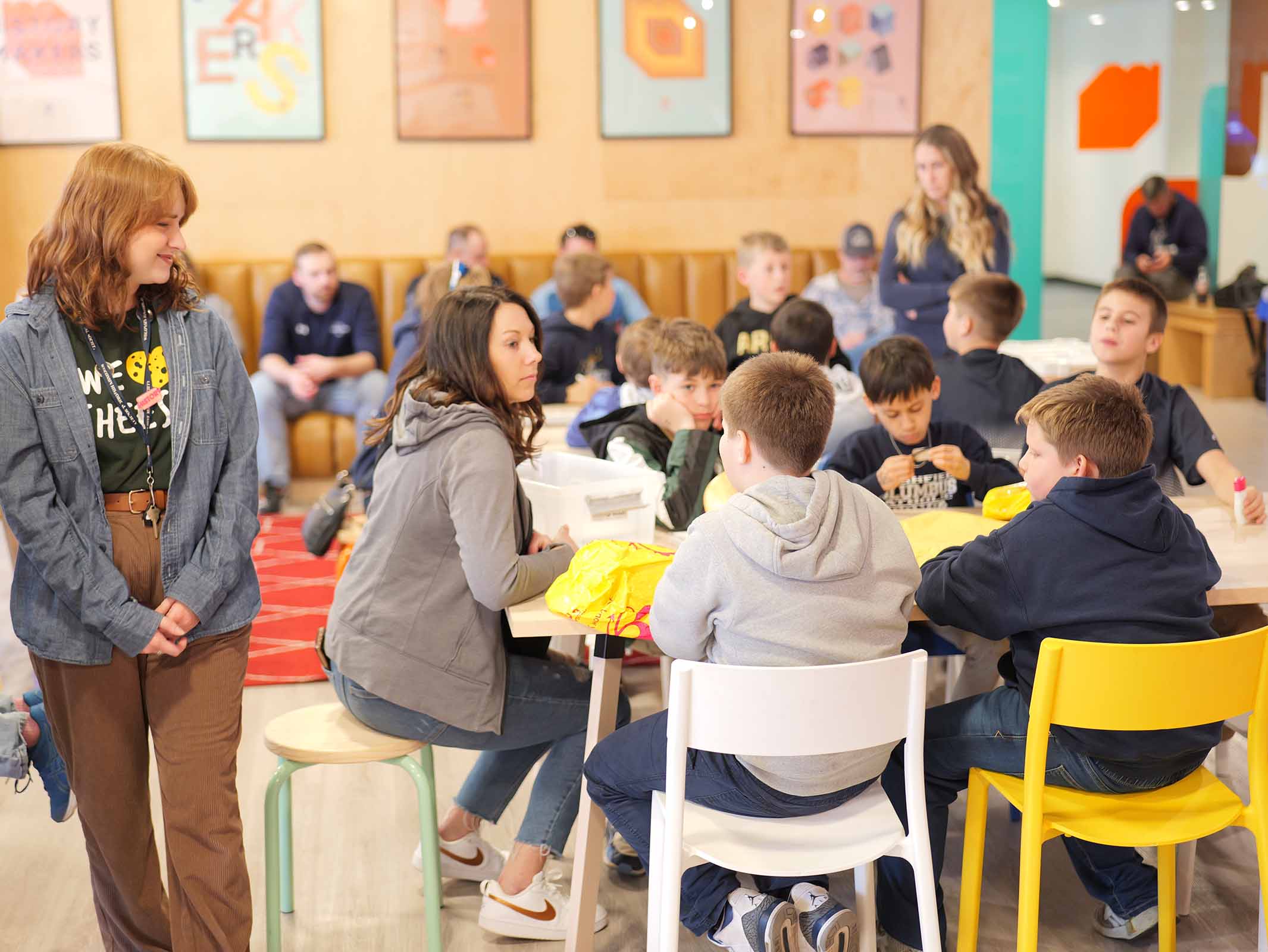 An educator observes while kids participate in a field trip at the history maker space