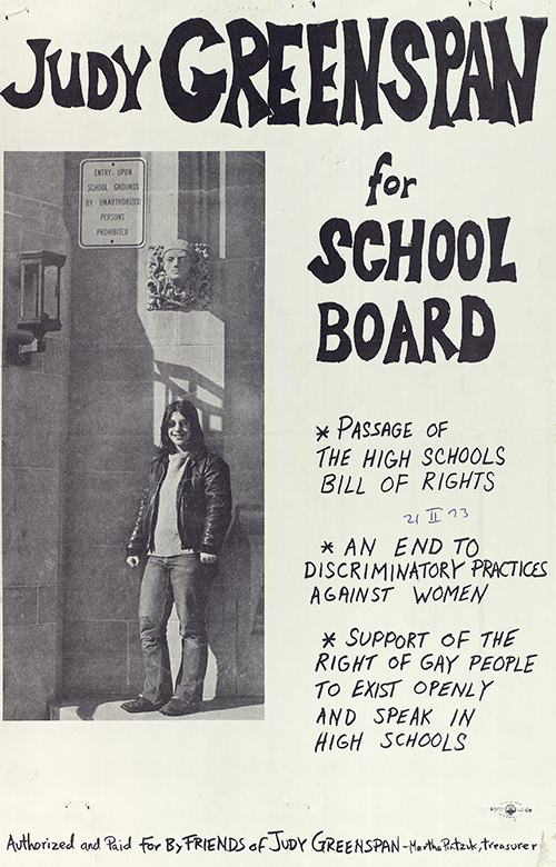 Judy Greenspan smiles happily at the camera in this outdoor photograph, wearing a leather jacket and a cowl neck like sweater. She used this photo in her campaign for School board.