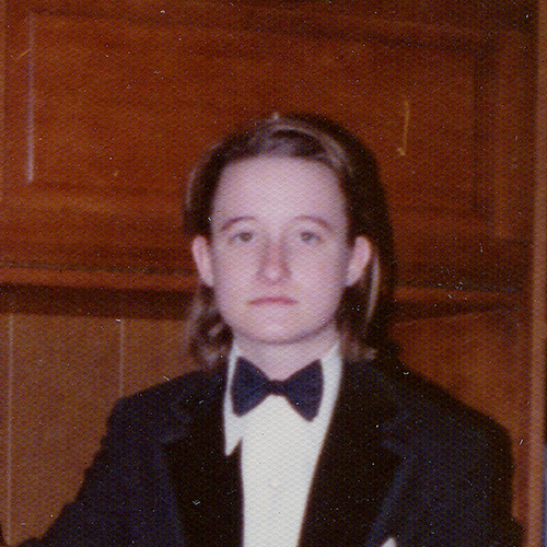 Lou Sullivan sits dramatically, and somewhat seriously, in a tuxedo with his hair slicked back behind his ears, stylishly. Lou Sullivan pictured in 1974 before attending the GPU’s drag ball. 
