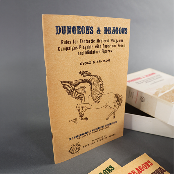 The cover featuring a winged creature with the body of a horse and the head of eagle on beige colored card stock, mostly black ink but the title is in deep blue. It reads 'Dungeons and Dragons: Rules for fantastic medieval wargames campaigns playable with paper and pencil and miniature figures. Gygax & Arneson. The Underworld & Wilderness adventures. Volume 3 of three booklets. Published by Tactical Studies Rules.'
