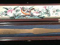 Interior of fan box. Lid is painted with bird and flower details. Cardboard insert in lower portion holds the fan in place while stored.